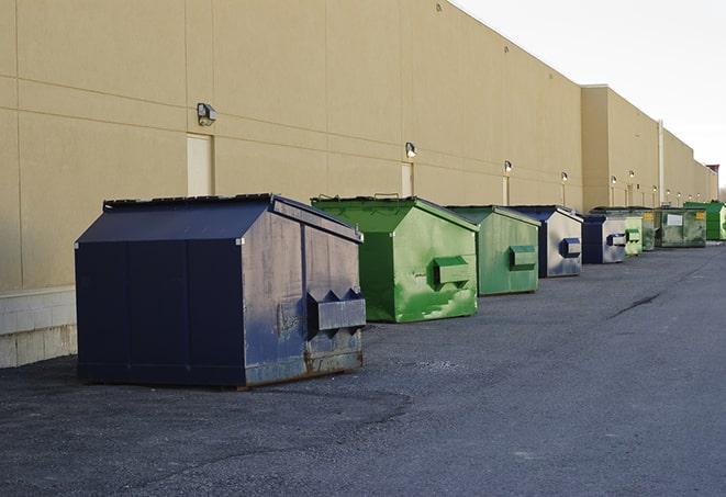 a compact construction dumpster being emptied by a waste disposal truck in Bloomer WI